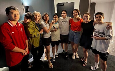 An undated photo released by Australia's Department of Home Affairs on March 11, 2026 shows two more members of the Iranian women's football team to claim asylum in Australia, player Mohaddeseh Zolfi (L) and support member Zahra Soltan Meshkeh Kar (3rd L), posing with their five other teammates who had earlier claimed asylum Fatemeh Pasandideh (2nd L), Atefeh Ramezanizadeh (4th L), Mona Hamoudi (C), Zahra Ghanbari (4th R), and Zahra Sarbali (R), along with two other local officials (2nd and 3rd R) in Sydney. (AUSTRALIAN DEPARTMENT OF HOME AFFAIRS / AFP)