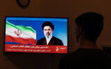 A man watches a televised statement purportedly by Iran's new supreme leader Mojtaba Khamenei on March 12, 2026. (AFP)