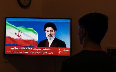 A man watches a televised statement purportedly by Iran's new supreme leader Mojtaba Khamenei on March 12, 2026. (AFP)