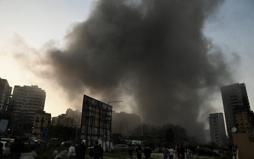 People watch a plume of smoke rising following an Israeli airstrike in the neighbourhood of Bashoura in central Beirut on March 12, 2026. (JOSEPH EID / AFP) People watch a plume of smoke rising following an Israeli airstrike in the neighbourhood of Bashoura in central Beirut on March 12, 2026. (JOSEPH EID / AFP)