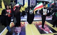 Iranians stand on posters depicting images of the US president Donald Trump and Israeli Prime Minister Benjamin Netanyahu as they take part in the Quds Day rally in Tehran on March 13, 2026. (AFP)