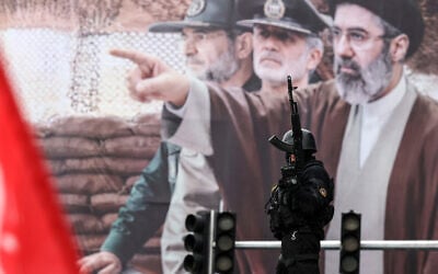 An Iranian security force officer stands guard next to a huge billboard of Iran's newly nominated supreme leader Ayatollah Mojataba Khamenei during Al-Quds (Jerusalem) Day rally in Tehran on March 13, 2026. (Photo by AFP) An Iranian security force officer stands guard next to a huge billboard of Iran's newly nominated supreme leader Ayatollah Mojataba Khamenei during Al-Quds (Jerusalem) Day rally in Tehran on March 13, 2026. (Photo by AFP)