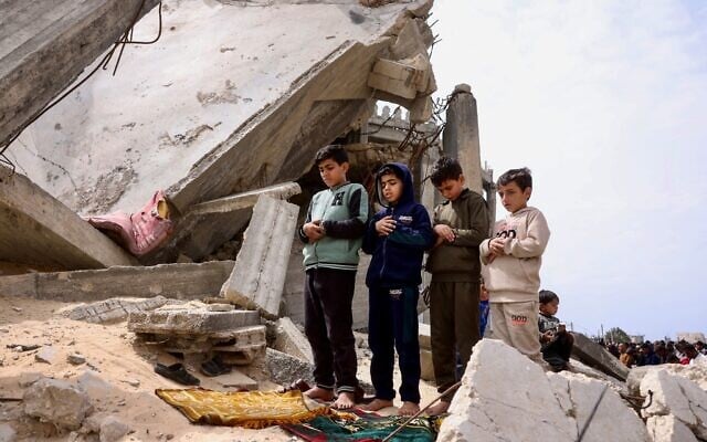 Palestinian boys pray during the last Friday noon prayer of the Muslim holy fasting month of Ramadan, outside the Al-Talbani Mosque, destroyed by the Israeli military in Khan Younis, in the southern Gaza Strip, March 13, 2026. (Bashar Taleb / AFP) Palestinian boys pray during the last Friday noon prayer of the Muslim holy fasting month of Ramadan, outside the Al-Talbani Mosque, destroyed by the Israeli military in Khan Younis, in the southern Gaza Strip, March 13, 2026. (Bashar Taleb / AFP)