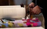 Rabbi Josh Bennett of Temple Israel unravels the Torah during a Bat Mitzvah service at Tam O'Shanter Country Club on March 13, 2026 in West Bloomfield, Michigan. (Emily Elconin/Getty Images/AFP)
