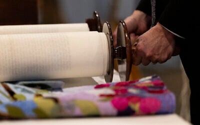 Rabbi Josh Bennett of Temple Israel unravels the Torah during a Bat Mitzvah service at Tam O'Shanter Country Club on March 13, 2026 in West Bloomfield, Michigan. (Emily Elconin/Getty Images/AFP)