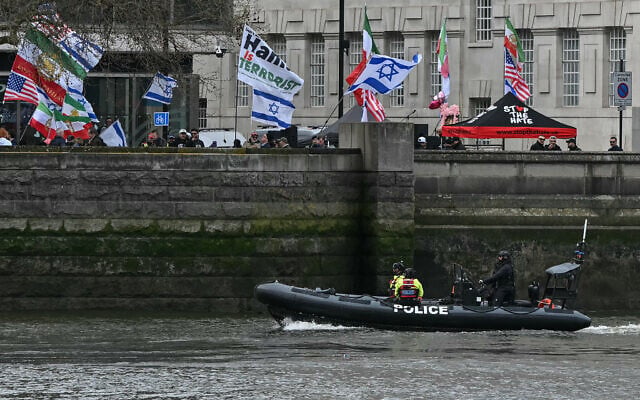 Counter-protesters wave Israeli and US flags at a position on the opposite side of the River Thames from an Al-Quds Day protest in central London on March 15, 2026. (Justin Tallis/AFP)