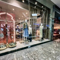 A man walks past shops in a mall in Dubai, where, amid Iranian attacks, people are beginning to shop for new clothes and gifts ahead of the start of the Eid al-Fitr festival, which marks the end of the Muslim holy fasting month of Ramadan, on March 16, 2026. (AFP)