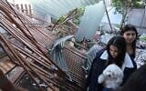 Residents looks at the damage to the back yard of a home at the site of a strike that hit a residential neighborhood in Rishon Lezion on March 17, 2026. (Jack GUEZ / AFP)