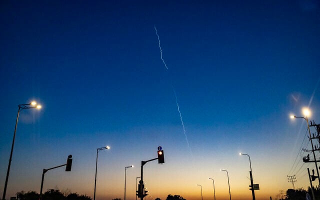 A rocket trail from the Iron Dome missile defense system is seen in the sky from a car waiting at a red light near Afula, northern Israel, on March 17, 2026, amid Hezbollah rocket attacks.  (Odd ANDERSEN / AFP)