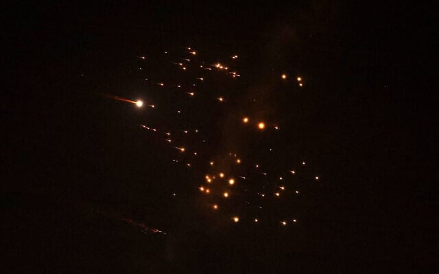 El 18 de marzo de 2026 se ven rastros de cohetes de un misil iraní con una ojava de racimo en el cielo sobre la ciudad costera de Netanya. (Jack Guez/AFP)