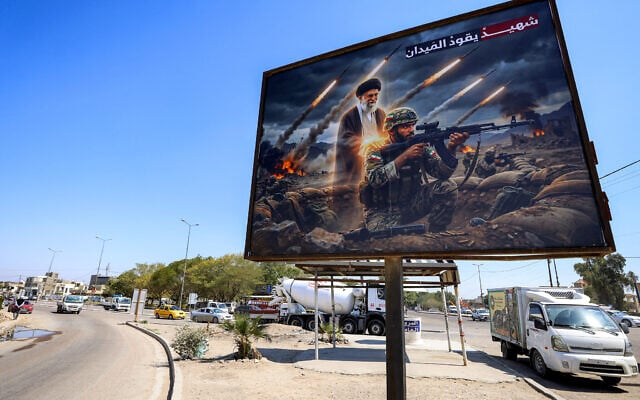 A billboard depicting Ayatollah Ali Khamenei, Iran's late supreme leader who was killed on February 28 in an Israeli strike in Tehran, standing behind an Iranian soldier with a caption in Arabic reading 'A martyr leads the battlefield' is displayed along a road in the Ameriyah neighborhood in western Baghdad on March 18, 2026 (AHMAD AL-RUBAYE / AFP) A billboard depicting Ayatollah Ali Khamenei, Iran's late supreme leader who was killed on February 28 in an Israeli strike in Tehran, standing behind an Iranian soldier with a caption in Arabic reading 'A martyr leads the battlefield' is displayed along a road in the Ameriyah neighborhood in western Baghdad on March 18, 2026 (AHMAD AL-RUBAYE / AFP)