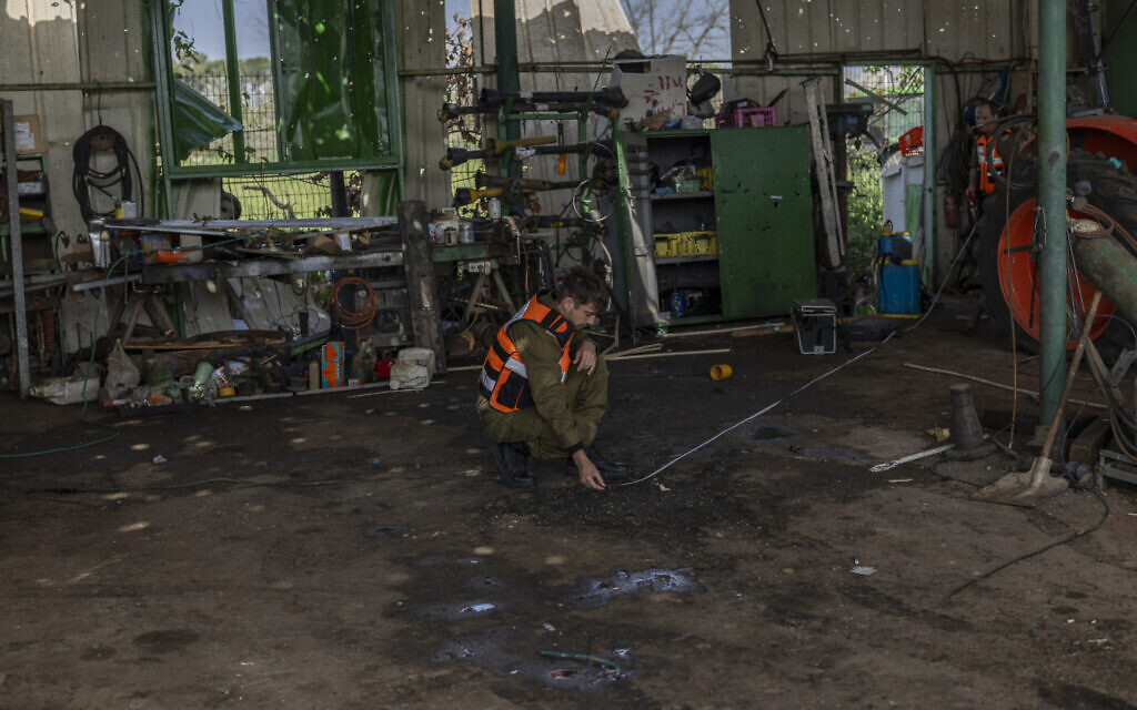 A member of the Home Front Command inspects the site where a a foreign worker was killed during an Iranian missile attack in Moshav Adanim, near Hod Hasharon in central Israel, on March 19, 2026 (Ilia YEFIMOVICH / AFP) / A member of the Home Front Command inspects the site where a a foreign worker was killed during an Iranian missile attack in Moshav Adanim, near Hod Hasharon in central Israel, on March 19, 2026 (Ilia YEFIMOVICH / AFP) /
