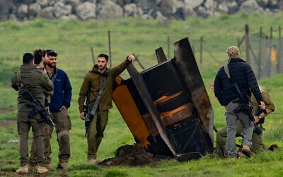 Israeli security personnel secure an area around a rocket partly buried in a field in the Golan Heights bordering Lebanon, on March 19, 2026. (Odd Andersen / AFP)