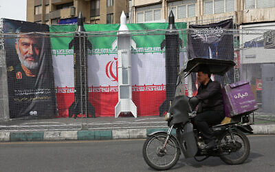 A motorist rides past the dummy models of Iranian missiles installed along the roadside at the Valiasr Square, in Tehran, Iran, on March 22, 2026. (AFP)