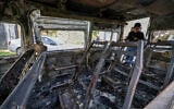 A Palestinian boy looks at a burnt vehicle following an attack by extremist settlers in the village of Jalud, south of Nablus in the West Bank, on March 22, 2026. (JAAFAR ASHTIYEH / AFP)