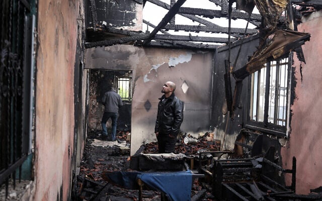 A Palestinian man inspects the remains of his burnt-out family home following a reported attack by extremist Israeli settlers in the village of Fandaqumiya, southwest of Jenin, in the West Bank on March 22, 2026. (Zain JAAFAR / AFP)