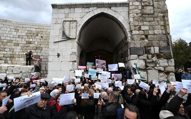 A Muslim woman holds a sign as Syrians hold a silent sit-in, called for by civil society, Christians, and shop owners affected by an official decision banning the sale of alcoholic beverages except in specific locations, in Bab Touma in Damascus on March 22, 2026. (Louai Beshara/AFP) A Muslim woman holds a sign as Syrians hold a silent sit-in, called for by civil society, Christians, and shop owners affected by an official decision banning the sale of alcoholic beverages except in specific locations, in Bab Touma in Damascus on March 22, 2026. (Louai Beshara/AFP)