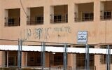Graffiti daubed by Jewish settlers that reads, "A good Arab is a dead Arab" stains the walls of the Palestinian Huwara Secondary School, where an Israeli flag reportedly placed on the school's roof by Israeli settlers was removed and the Palestinian flag restored by the school in Huwara, south of the city of Nablus in the West Bank on March 23, 2026.(Jaafar ASHTIYEH / AFP)
