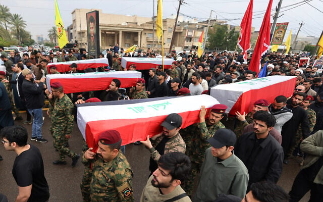 Members of the Popular Mobilization Force carry the coffins of people killed in a strike on a base in the Anbar province a day earlier, during a mass funeral in Baghdad, Iraq, on March 24, 2026. (AHMAD AL-RUBAYE / AFP)