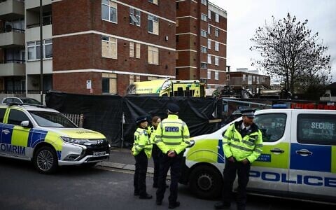 Police stand outside the scene of an antisemitic arson attack in the Golders Green neighborhood of north London, on March 24, 2026. (Henry NICHOLLS / AFP)