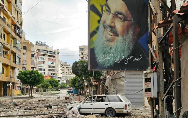 Uma faixa com a imagem de Hassan Nasrallah, o líder assassinado do movimento terrorista xiita libanês Hezbollah, está pendurada em um prédio ao longo de uma rua repleta de destroços após um ataque aéreo israelense noturno que atingiu um bairro nos subúrbios do sul de Beirute em 25 de março de 2026. (AFP) Uma faixa com a imagem de Hassan Nasrallah, o líder assassinado do movimento terrorista xiita libanês Hezbollah, está pendurada em um prédio ao longo de uma rua repleta de destroços após um ataque aéreo israelense noturno que atingiu um bairro nos subúrbios do sul de Beirute em 25 de março de 2026. (AFP)