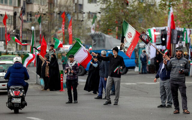 People gather with Iranian flags along Enghelab (Revolution) Square in central Tehran on March 25, 2026. (AFP) People gather with Iranian flags along Enghelab (Revolution) Square in central Tehran on March 25, 2026. (AFP)