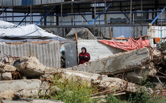 A woman stands outside a tent encampment at the Bureij refugee camp in the central Gaza Strip, on March 27, 2026. (Eyad Baba / AFP)