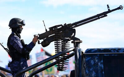 Security personnel stand guard as Houthi supporters gather during a rally in solidarity with Iran and Lebanon, amid the US-Israeli war with Iran, in the Houthi-held Yemeni capital Sanaa on March 27, 2026. (Mohammed HUWAIS / AFP)