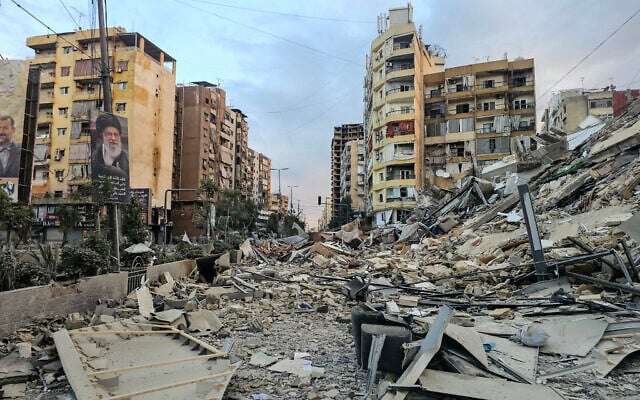A photograph shows a portrait of Iran's slain supreme leader Ayatollah Ali Khamenei and the rubble of a destroyed building at the site of an overnight Israeli airstrike in Beirut's southern suburbs, Lebanon, on March 28, 2026. (AFP)