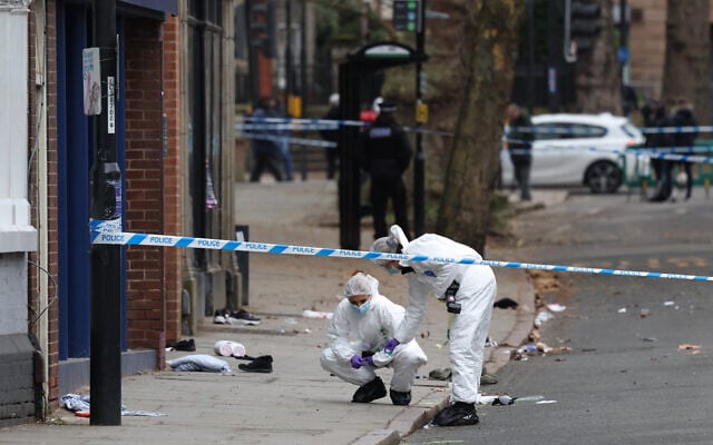 Police forensic officers work amongst a variety of personal items seen covering the road, inside a cordon set up on Friar Gate in central Derby, central England on March 29, 2026, after a man was arrested the previous night when a car hit pedestrians, wounding seven people. (Darren Staples / AFP) Police forensic officers work amongst a variety of personal items seen covering the road, inside a cordon set up on Friar Gate in central Derby, central England on March 29, 2026, after a man was arrested the previous night when a car hit pedestrians, wounding seven people. (Darren Staples / AFP)
