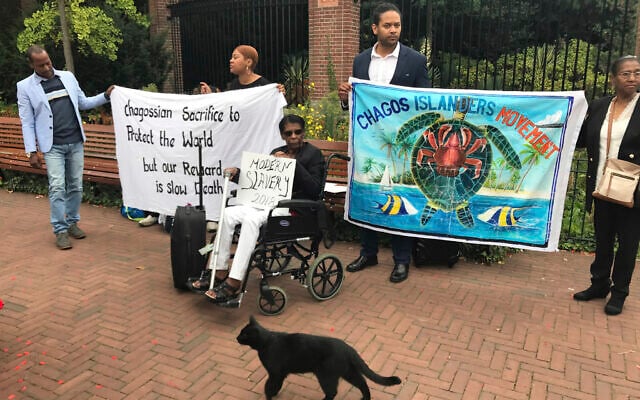 Protesters advocating for the rights of Chagos Islanders hold a placard and banners outside the World Court in The Hague, Netherlands, September 3, 2018. (AP Photo/Mike Corder)
