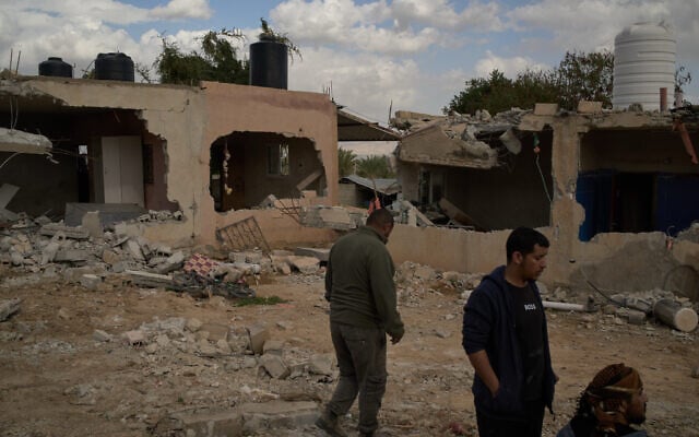 Bedouins stand in front of houses that, according to local residents, were heavily damaged the previous day during an attack by extremist Israeli settlers in Al-Dyouk Al-Tahta area, on the outskirts of the West Bank city of Jericho, February 11, 2026. (AP Photo/Leo Correa)