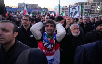 Government supporters mourn during a gathering after state TV officially announced the death of Iranian Supreme Leader Ayatollah Ali Khamenei, shown in the poster, in Tehran, March 1, 2026. (AP/Vahid Salemi)