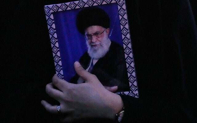 A government supporter holds a picture of the Iranian Supreme Leader Ayatollah Ali Khamenei during a gathering after state TV officially announced the death of Khamenei, in Tehran, Iran, March 1, 2026. (AP/Vahid Salemi)