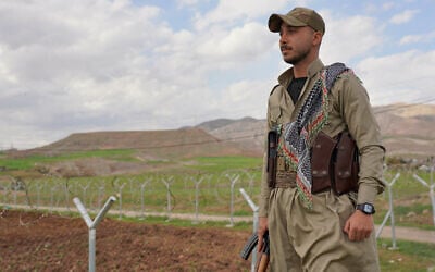 Member of the Democratic Party of Iranian Kurdistan PDKI stands at a checkpoint leading to their base in Koya district of Irbil, Iraq, Friday, Feb. 27, 2026. (AP Photo/Rashid Yahya)