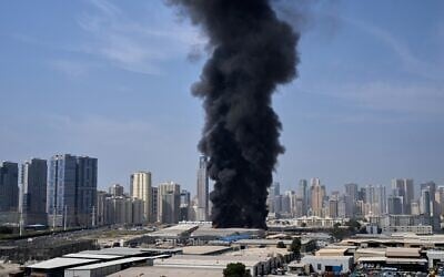 A black plume of smoke rises from a warehouse at the industrial area of Sharjah City in the United Arab Emirates following reports of Iranian strikes in Dubai, United Arab Emirates, March 1, 2026. (AP Photo/Altaf Qadri)