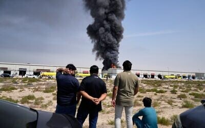 Residents watch as the flames and a black plume of smoke rises from a warehouse at the industrial area of Sharjah City in the United Arab Emirates following reports of Iranian strikes in Dubai, United Arab Emirates, Sunday, March 1, 2026. (AP Photo/Altaf Qadri) Residents watch as the flames and a black plume of smoke rises from a warehouse at the industrial area of Sharjah City in the United Arab Emirates following reports of Iranian strikes in Dubai, United Arab Emirates, Sunday, March 1, 2026. (AP Photo/Altaf Qadri)
