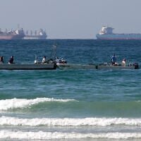 Fishermen work in front of oil tankers south of the Strait of Hormuz Jan. 19, 2012, offshore the town of Ras Al Khaimah in United Arab Emirates. (AP/Kamran Jebreili)