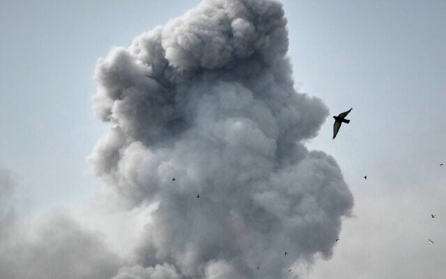 A bird flies by a plume of smoke rising after a strike in Tehran, Iran, March 2, 2026. (AP Photo/Vahid Salemi)