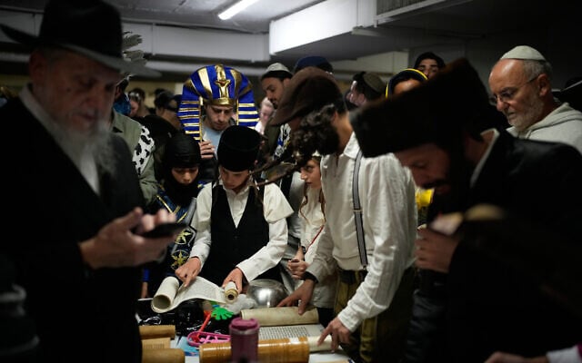 Jewish men and children, some dressed in costumes, read the Scroll of Esther as they celebrate the holiday of Purim in an underground parking garage as a precaution against Iranian missile attacks, in Tel Aviv, March 2, 2026. (AP Photo/Ohad Zwigenberg) Jewish men and children, some dressed in costumes, read the Scroll of Esther as they celebrate the holiday of Purim in an underground parking garage as a precaution against Iranian missile attacks, in Tel Aviv, March 2, 2026. (AP Photo/Ohad Zwigenberg)