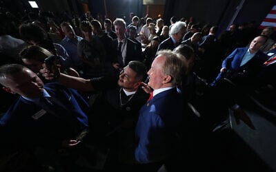 Texas Attorney General Ken Paxton, a Republican candidate for the US Senate, poses for a selfie with a supporter during a primary election night watch party, in Dallas, March 3, 2026. (Julio Cortez/AP)