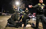 Police officers detain a man at the Holocaust memorial in Berlin, Germany, after another man was seriously injured, February 21, 2025. (Ebrahim Noroozi/AP)