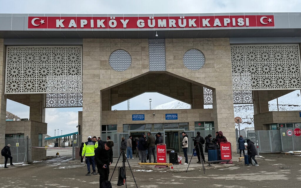 People, mostly Iranians, wait after crossing from Iran at the Kapikoy border crossing in eastern Van province, Turkey, Thursday, March 5, 2026. (AP Photo/Serra Yedikardes)