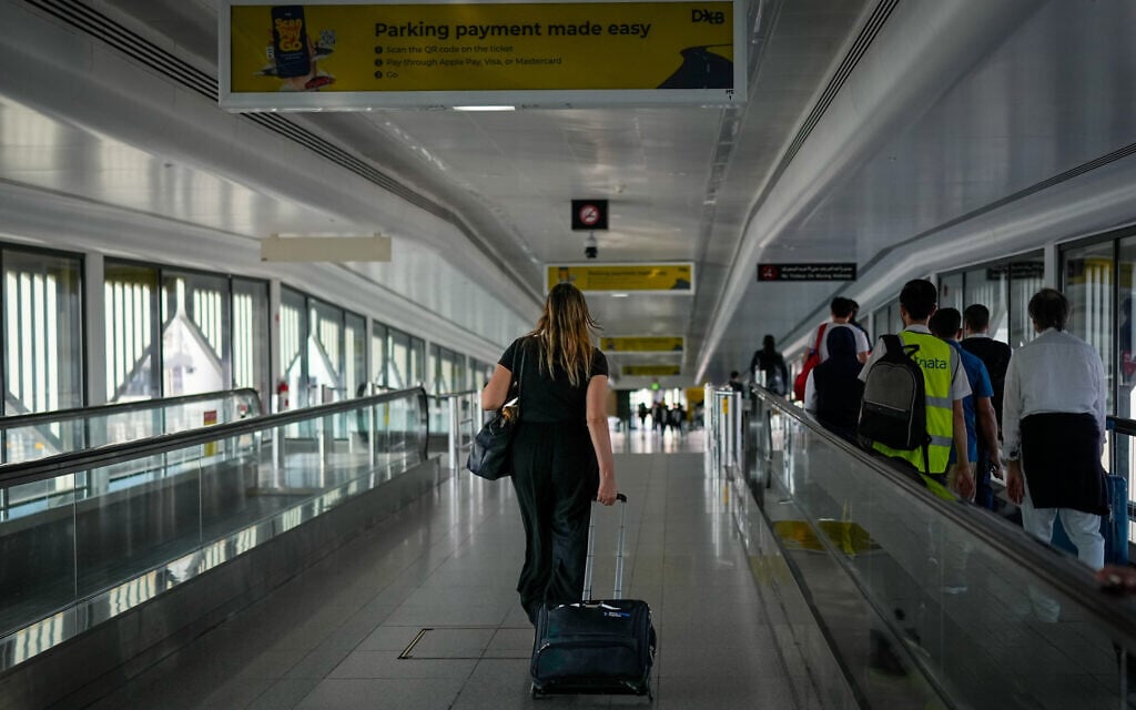 A passenger walks in the Dubai International Airport building as the airport resumes limited operations in Dubai, United Arab Emirates, Thursday, March 5, 2026. (AP Photo/Altaf Qadri)