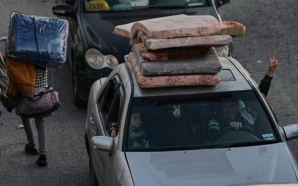 A family flashes victory signs as they flee Israeli airstrikes in Dahiyeh, Beirut's southern suburbs, while sitting in traffic on a highway in Beirut, Lebanon, Thursday, March 5, 2026. (AP Photo/Bilal Hussein)
