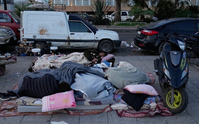 Displaced people fleeing Israeli airstrikes in Beirut's southern suburb of Dahiyeh sleep on the Beirut corniche, Lebanon, March 6, 2026. (AP Photo/Hussein Malla)