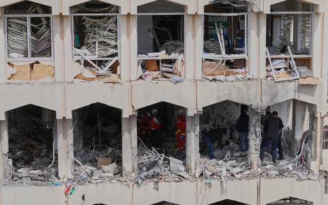 Security officers check the damage at a building struck by an Israeli airstrike in the southern port city of Sidon, Lebanon, March 6, 2026. (AP Photo/Mohammed Zaatari)