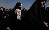 Pro-government demonstrators march against the ongoing US-Israeli military campaign with a picture of the the late supreme leader, Ayatollah Ali Khamenei, in Tehran, Iran, March 6, 2026. (AP/Vahid Salemi)