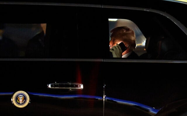 US President Donald Trump talks on his cellphone in his limousine, known as "The Beast," upon his arrival at Joint Base Andrews, Maryland, March 6, 2026. (AP Photo/Luis M. Alvarez)