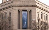A banner with a portrait of President Donald Trump is hung from the Department of Justice, Thursday, March 5, 2026, in Washington. (AP Photo/Jose Luis Magana)